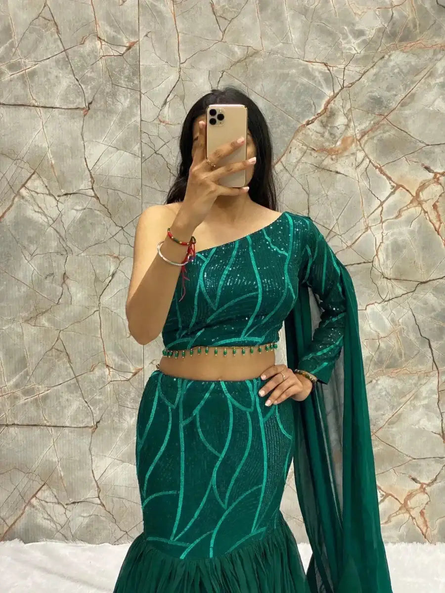Emerald green lehenga set with one-shoulder cropped top, tiered skirt, and dupatta