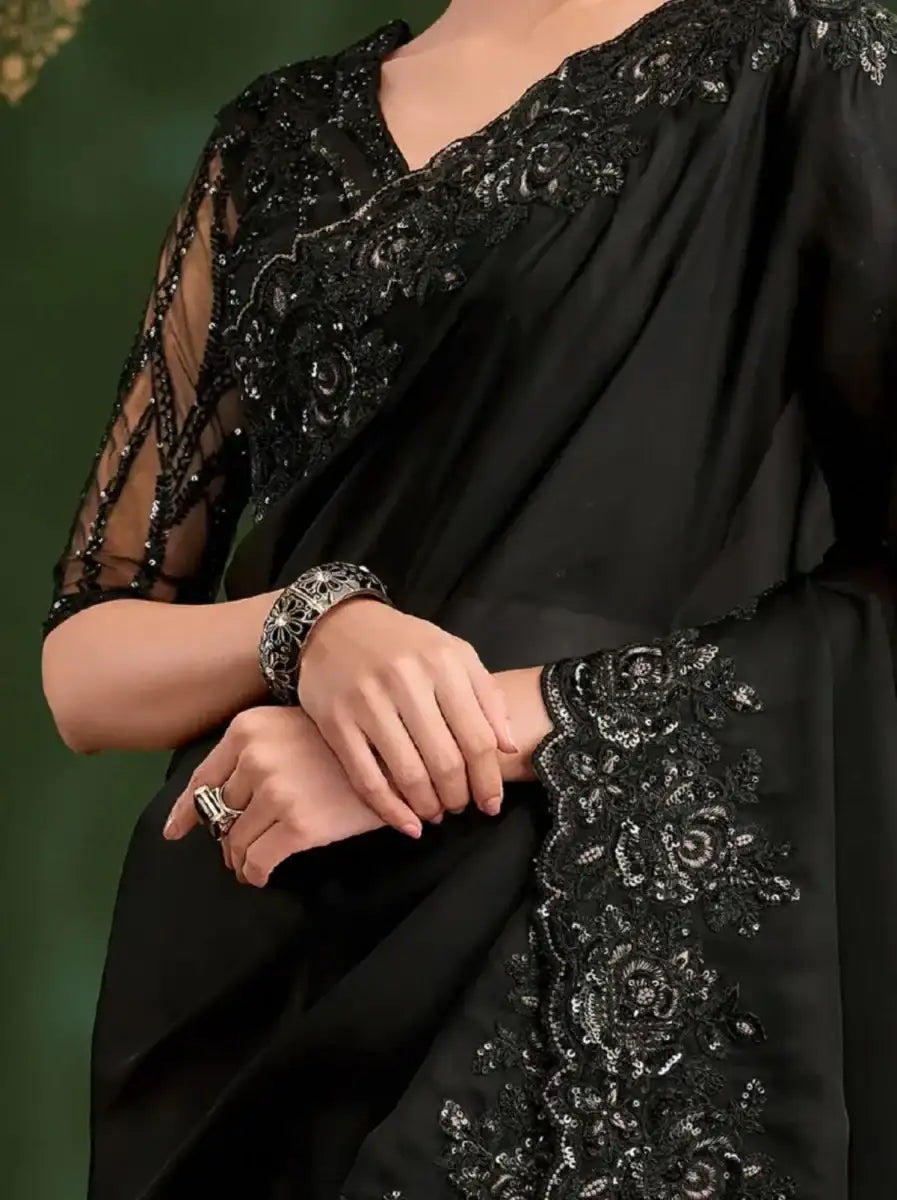 Black saree with ornate embroidered border on sleeves and front, draped over shoulder