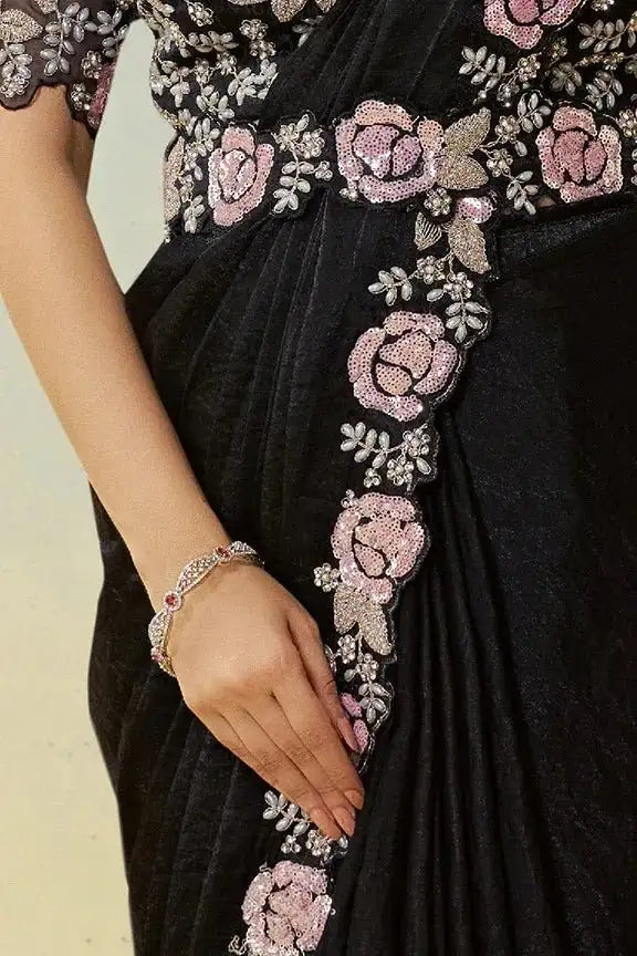 Jet black saree with pink rose embroidery and silver beadwork, hand with bangles