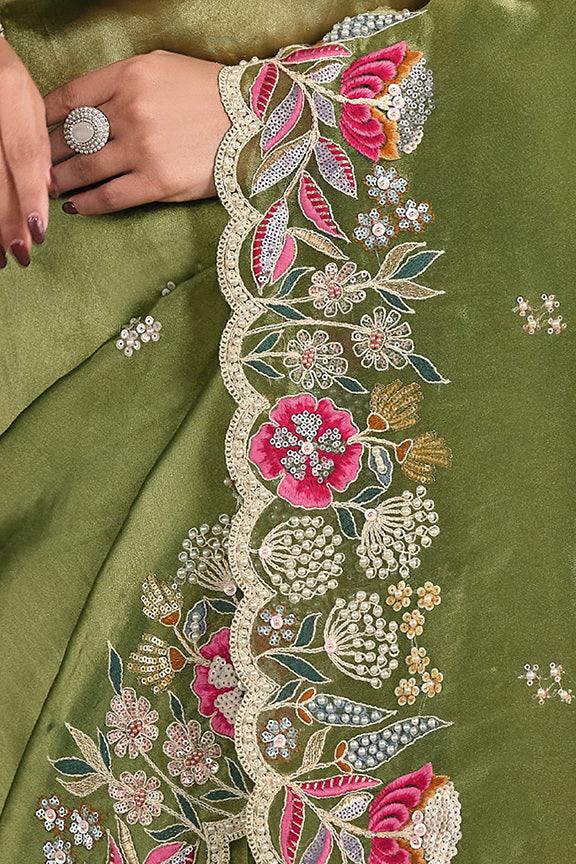 Green saree close-up with sequined floral embroidery along the border edge