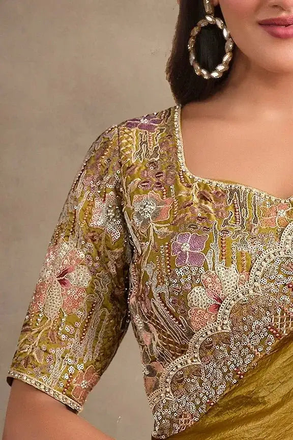 Olive-gold embroidered blouse with ornate floral border at neckline