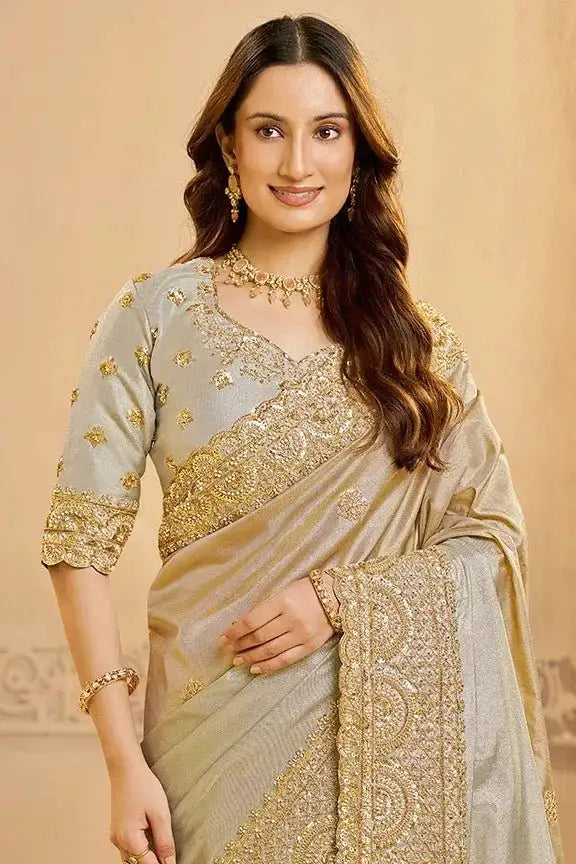 Metallic grey silk saree with gold embroidered blouse and detailed pallu border.
