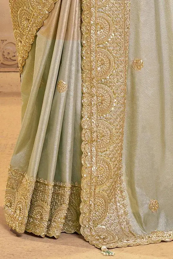Metallic grey silk saree with gold embroidered hem and decorative border on pallu.