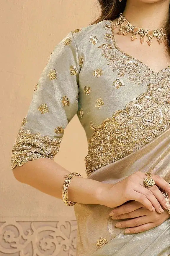 Metallic grey saree with gold embroidered blouse and embellished pallu.