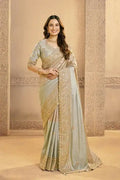 Metallic grey silk saree with gold zardozi embroidery and draped pallu.