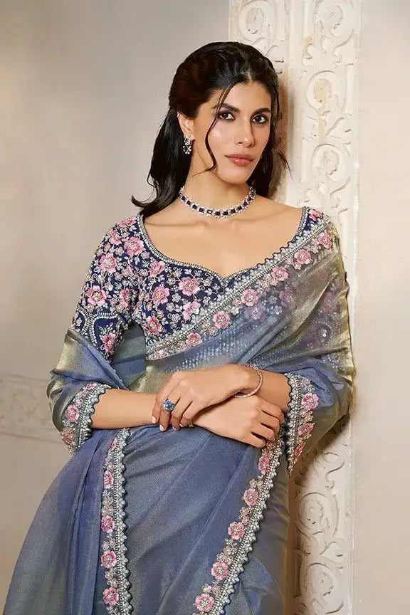 Blue saree with pink floral embroidered border and 3/4-sleeve blouse, draped