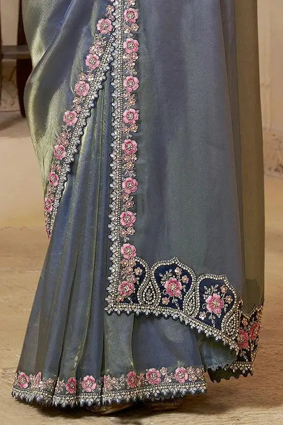 Blue saree with pink floral embroidery along pallu border and beaded hem edge