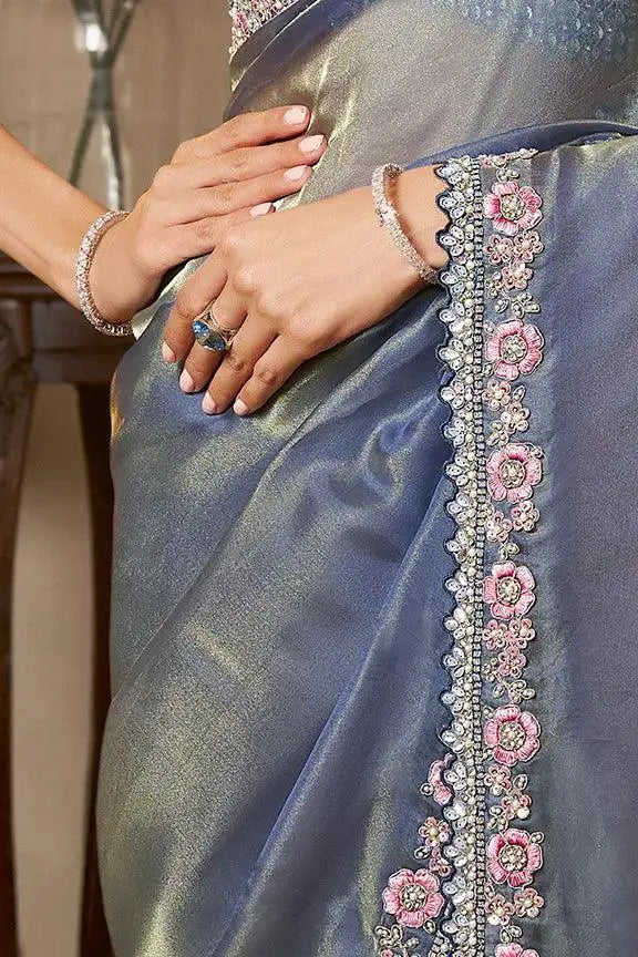 Blue saree fabric held together with pink floral embroidered vertical border