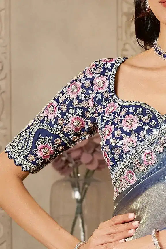 Close-up of blue saree blouse with pink floral embroidery and 3/4-length sleeves