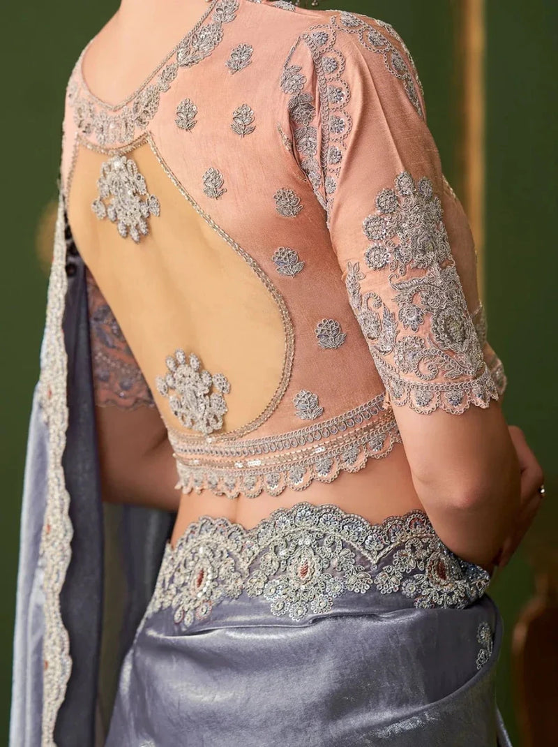 Metallic steel lavender saree with peach blouse and gold lace embroidery on bodice