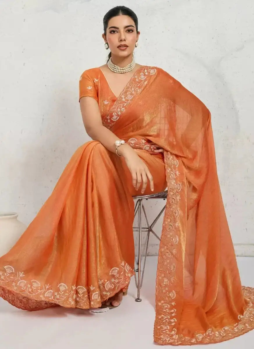 Orange shimmer chiffon saree with gold motifs and wide decorative border, draped