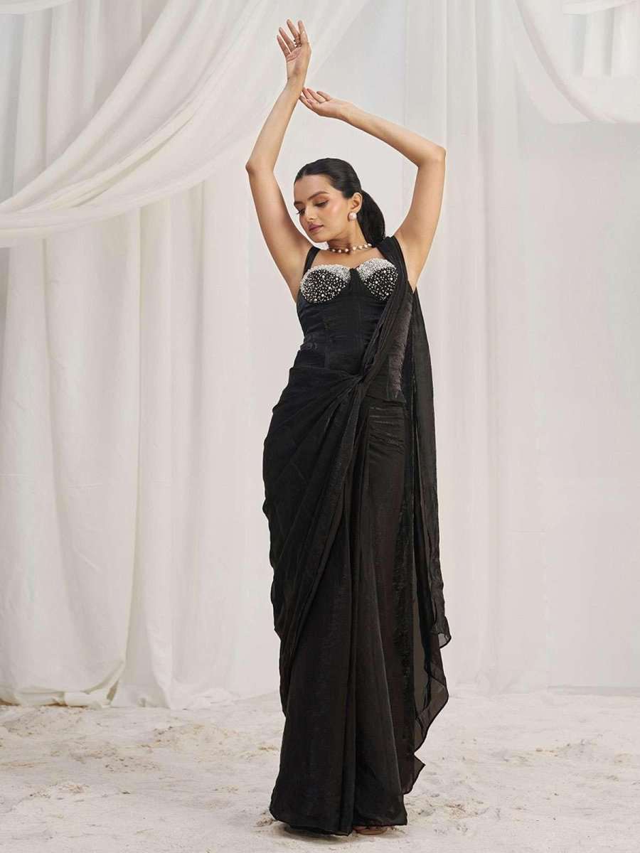 Corset-ready black saree with jeweled bodice and draped skirt, arms raised