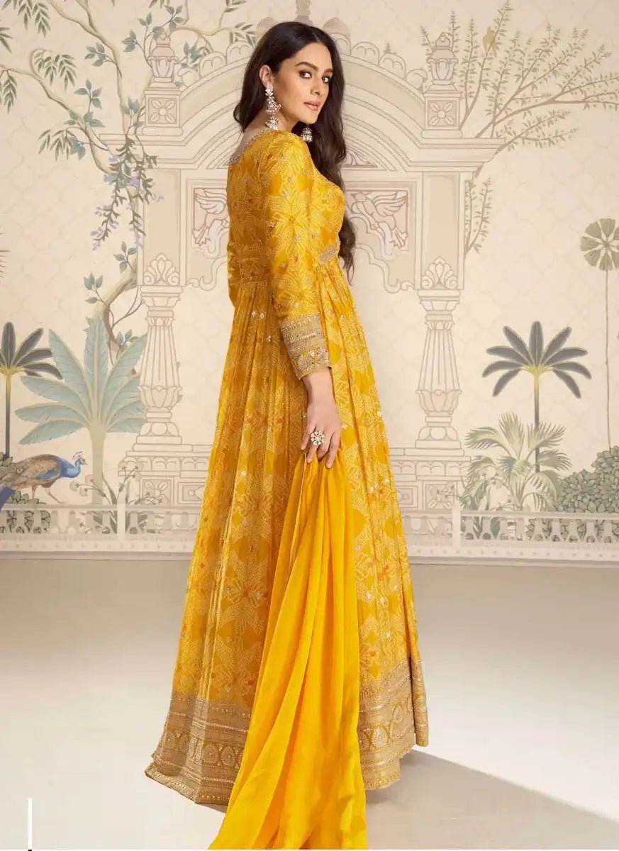 Mustard yellow embroidered bandhani silk gown with V-neck and flowing pleated skirt, side view