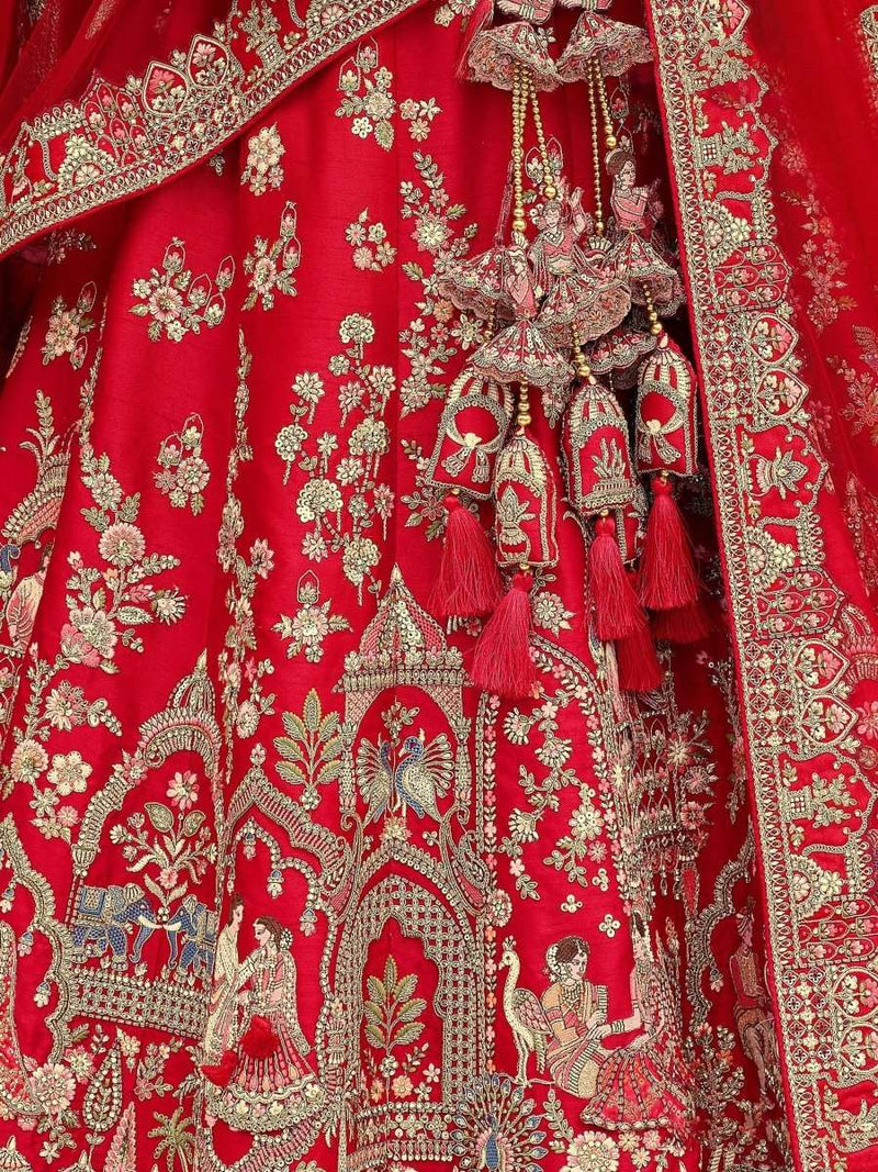 Close-up of crimson bridal lehenga fabric with intricate gold embroidery and tassel trim