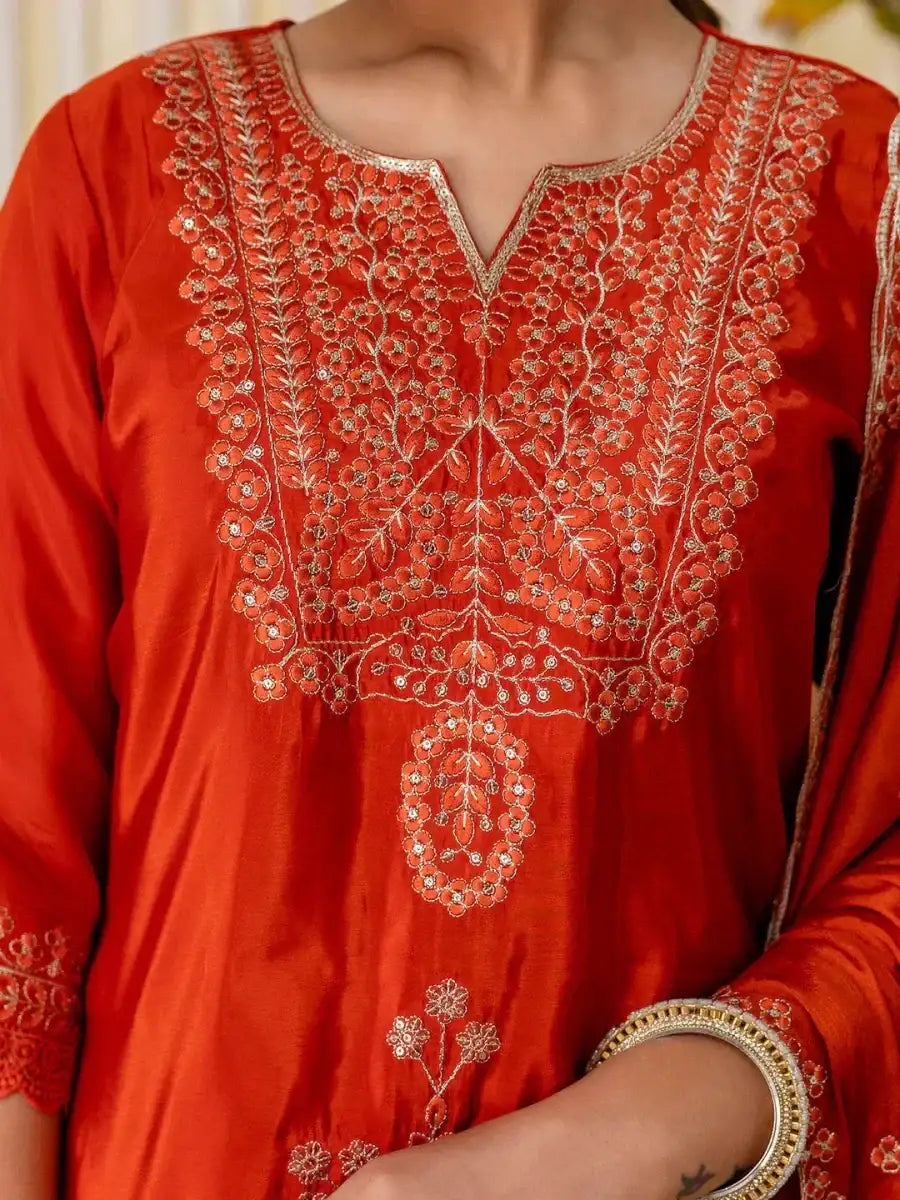 Rust red kurti with dense gold-toned embroidery at center yoke and neckline