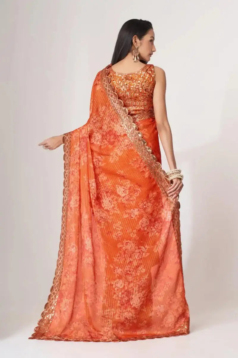 Orange sequin organza saree shown from the back with scalloped trim