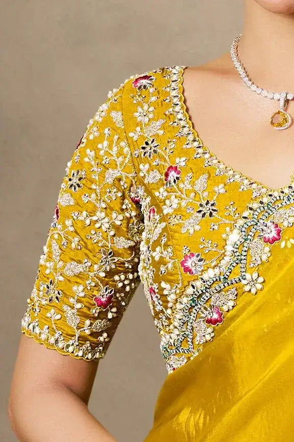 Yellow saree with jeweled floral embroidery at neckline and sleeve
