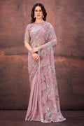 Light pink net saree with embroidered motifs and elbow-length stitched blouse