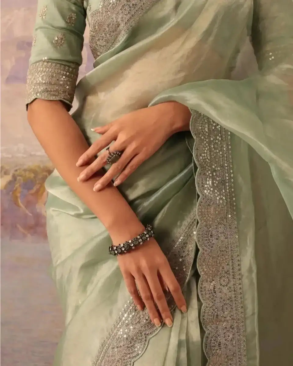 Mint green saree drape with gold sequin lace trim and beaded bracelet