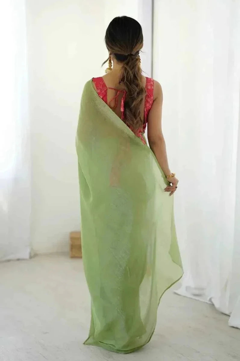 Back view of light green silk saree with red blouse and open-back drape