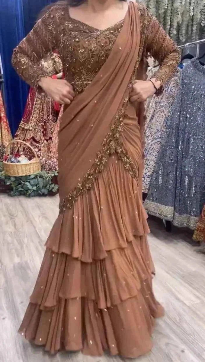 Nude peach ruffle saree dress with tiered skirt and gold sequin blouse, draped pallu