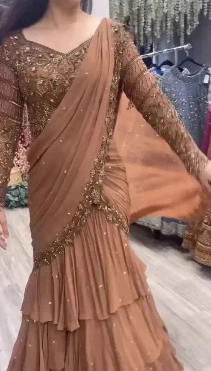 Nude peach ruffle saree with gold sequin border and draped pallu, long sleeves