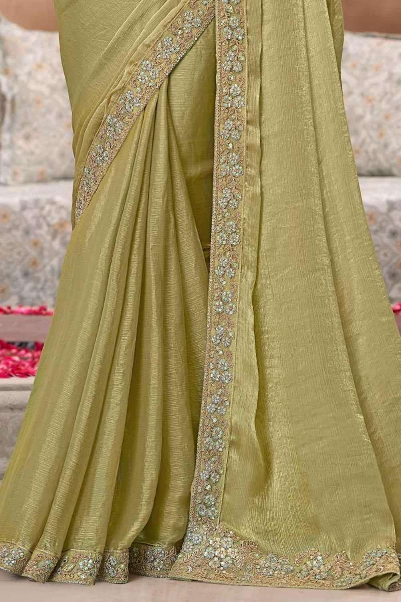 Olive-green satin saree with vertical gold zari trim and ornate hem border