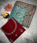 Aqua blue saree with multicolor embroidered border; red embroidered blouse piece