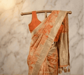 Peach shibori printed saree with wide gold border and tassel trim