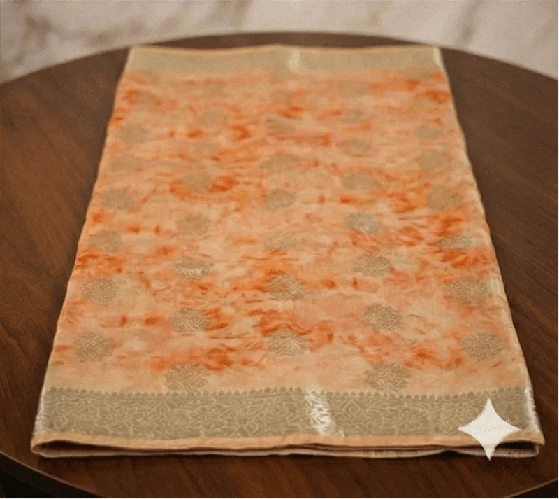 Peach shibori printed Banarasi silk saree folded with beige border