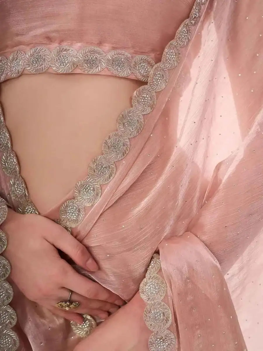 Peach saree pallu close-up with ornate silver-toned border and sequined texture