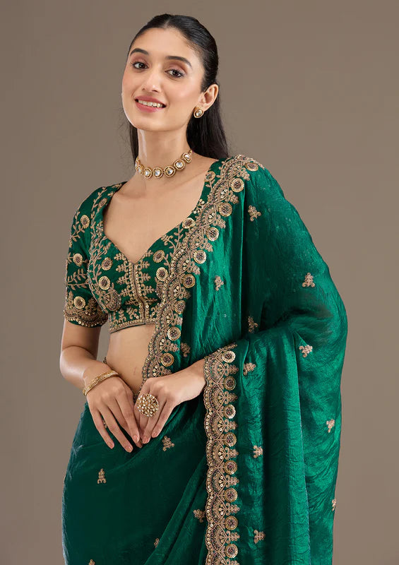 Green silk saree with gold zari and sequence work, ornate border