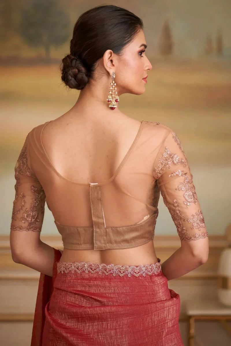 Back view of red embroidered saree with sheer brown blouse back and lace trim