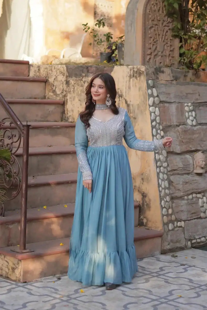 Blue sequined embroidered gown with long sleeves and tiered, flowy skirt
