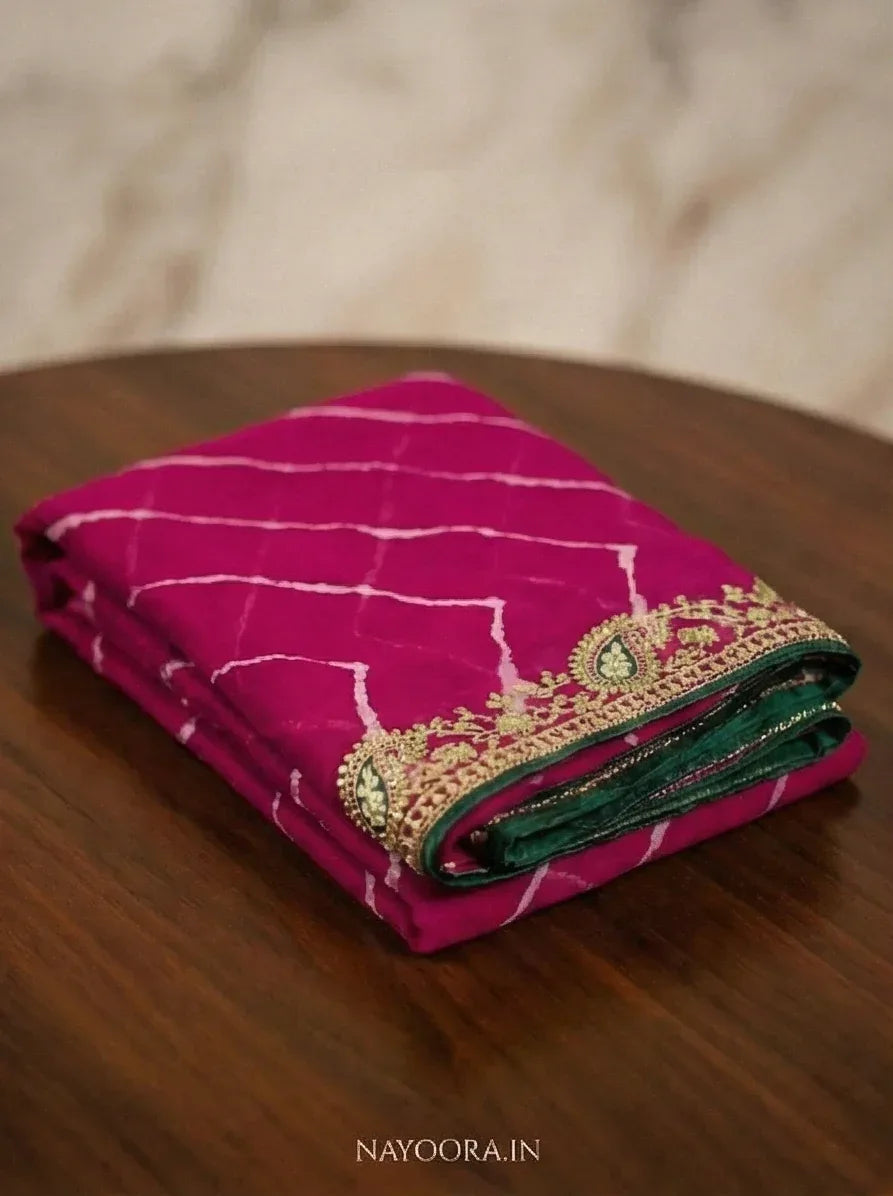 Rani pink leheriya saree fold with green inner band and gold embellished border