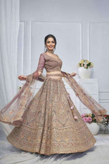 Bridal net lehenga with mauve embroidered blouse and tiered gold skirt, flowing dupatta