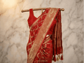Red Banarasi silk saree with gold patterned border and draped pallu