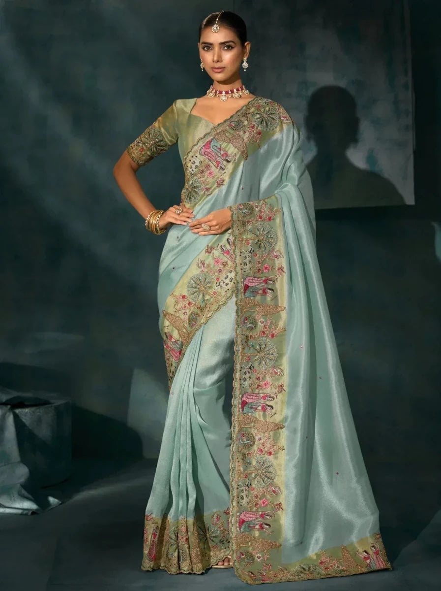 Aqua blue saree with patterned pallu, gold border, and floral embroidered panel