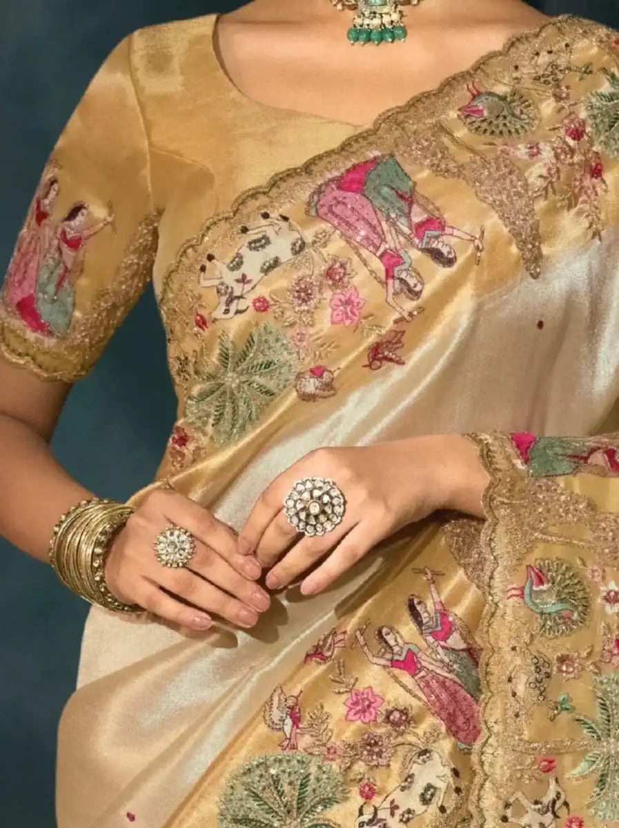 Golden cream saree close-up with embroidered panel, peacock and floral motifs
