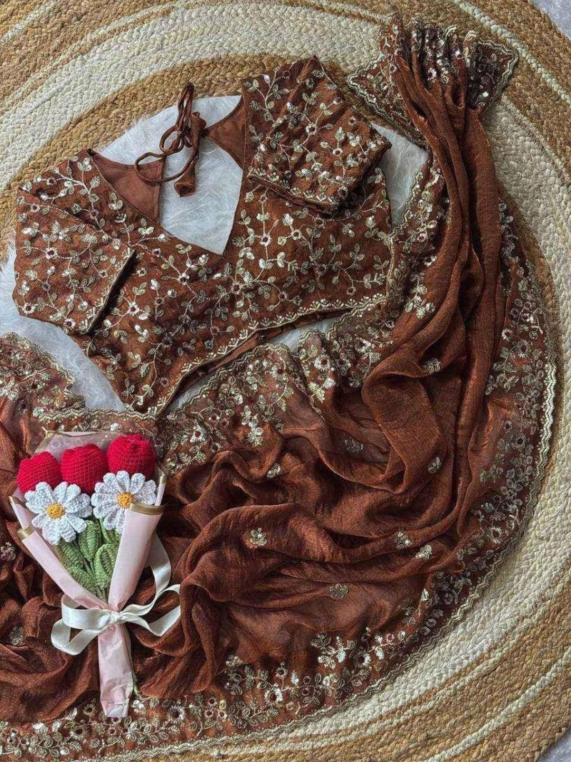 Rust brown chiffon saree with floral sequin motifs, folded with matching blouse pieces