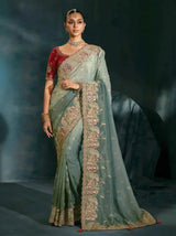 Sage green silk saree with ornate gold-embellished border and small motif details
