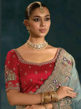 Sage green Banarasi silk saree with ornate gold-toned border and embroidered motifs