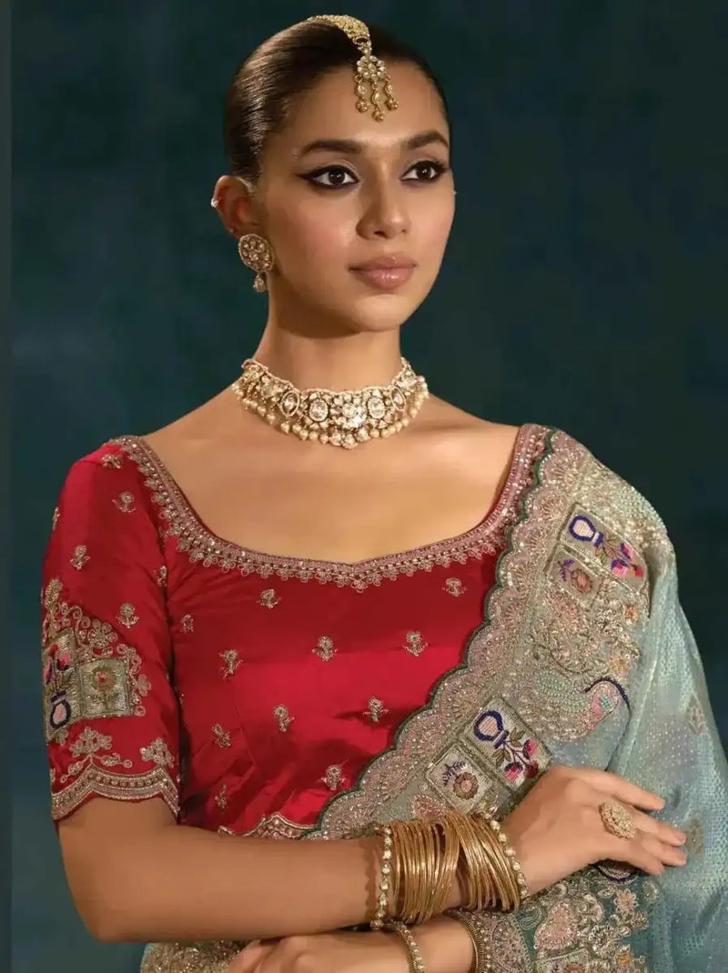 Sage green Banarasi silk saree with ornate gold-toned border and embroidered motifs