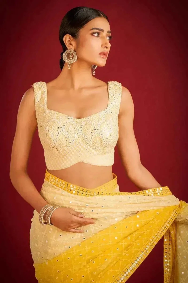 Yellow and cream sequin embroidered saree with sleeveless blouse and waist border