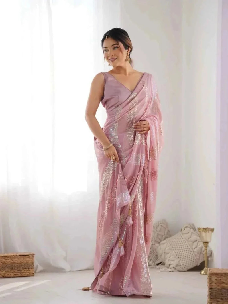 Pastel pink georgette saree with linear sequins, draped with pallu over the shoulder