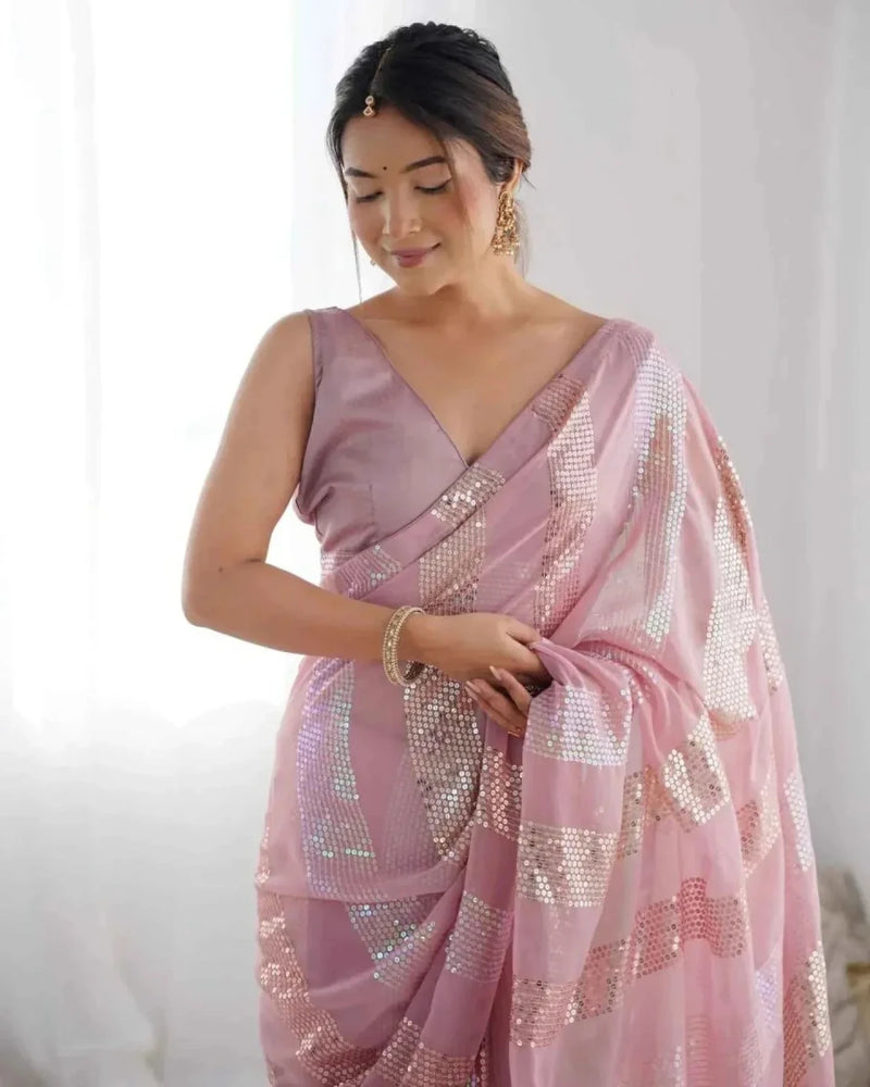 Pastel pink georgette saree with linear sequin stripes and gathered pleats at the waist