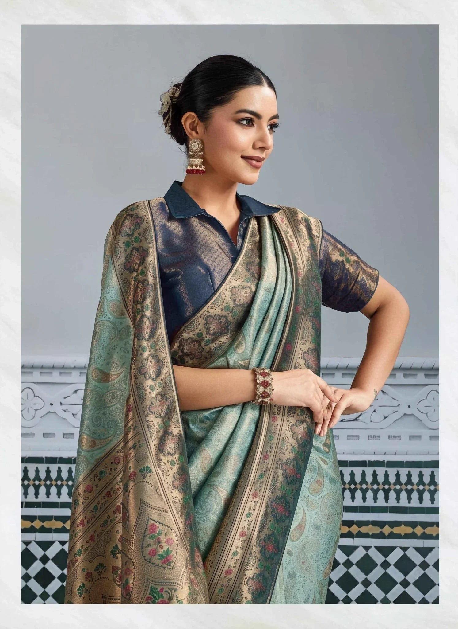 Woman wearing a platinum blue and green Kanjivaram silk saree with gold meenakari zari weaving and brocade collar blouse
