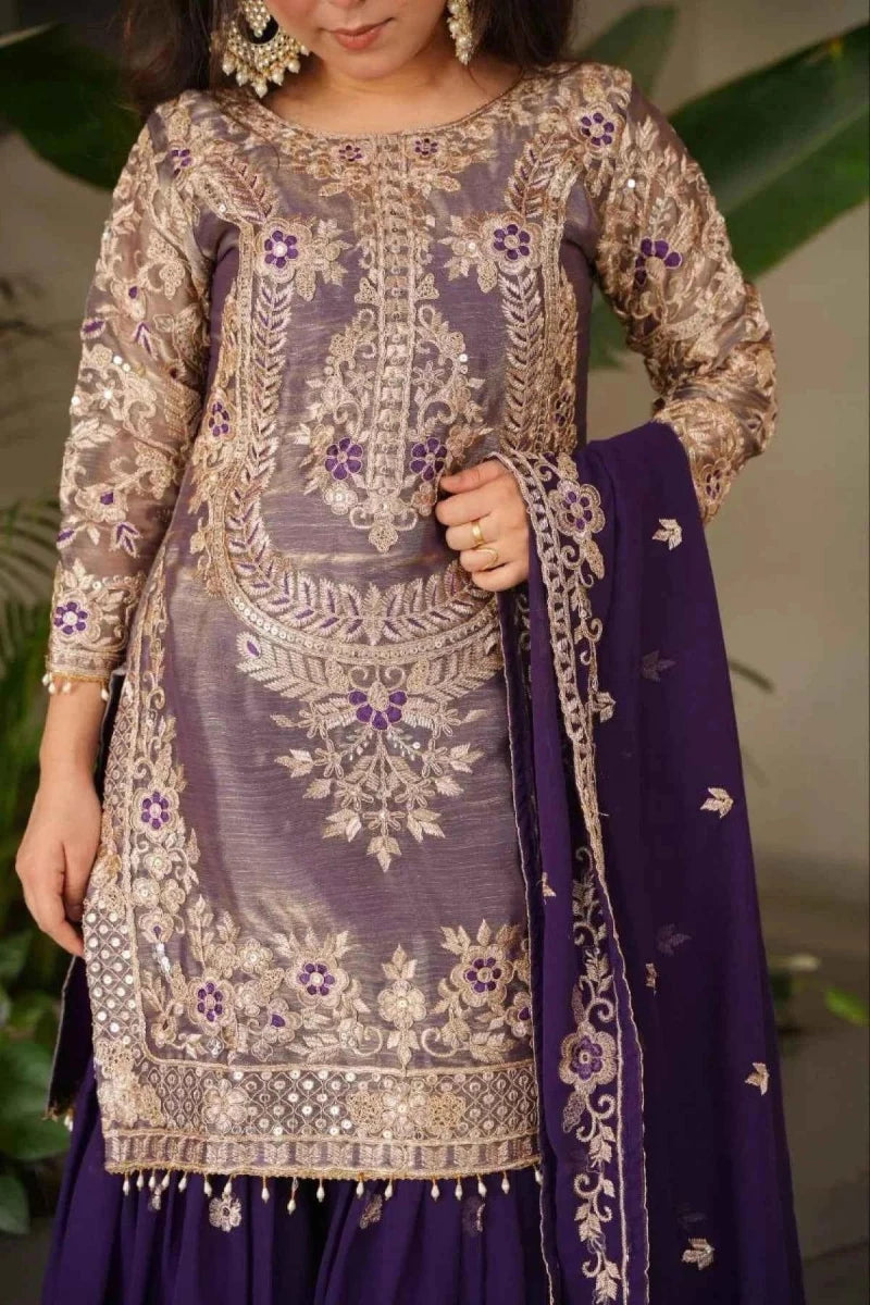 Detailed view of gold embroidery on long tunic with purple flared skirt and dupatta