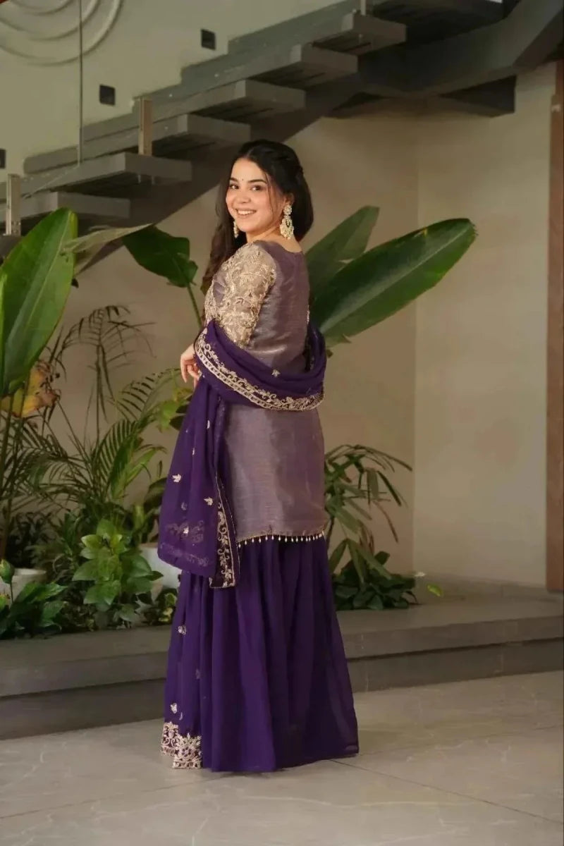 Side view of purple embroidered sharara suit with long tunic and draped dupatta