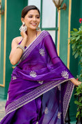 Smiling woman in elegant purple chiffon saree with intricate silver embroidery and matching jewelry